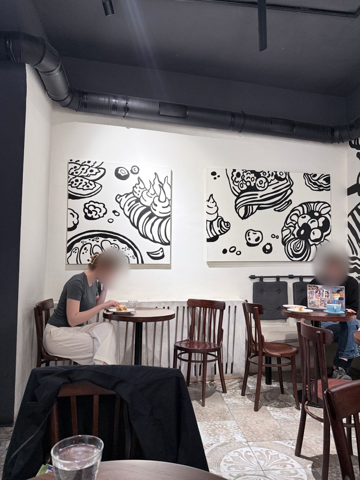 白黒のイラストが飾られたBabáの店内の壁